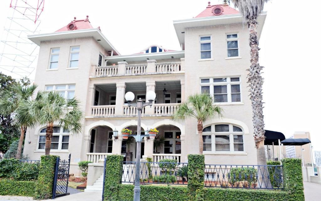 圣安东尼奥哈瓦那酒店的一座大型白色房子,前面有棕榈树