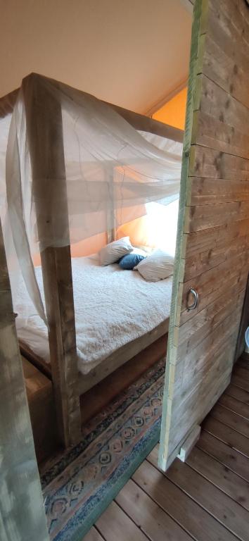 MortierLe Relais d'Artagnan - relais équestre的帐篷内一间卧室,配有一张床
