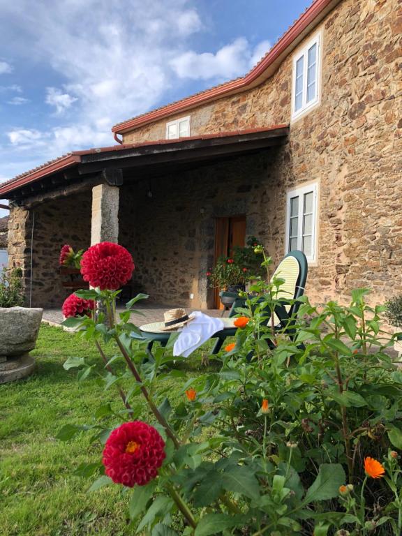 阿尔苏阿VUT Rural - Boente的院子里的石头房子,带桌子和鲜花