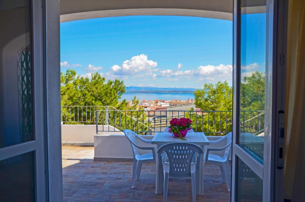 卡拉赛达Residence Fior di Sulcis的海景阳台上的桌椅