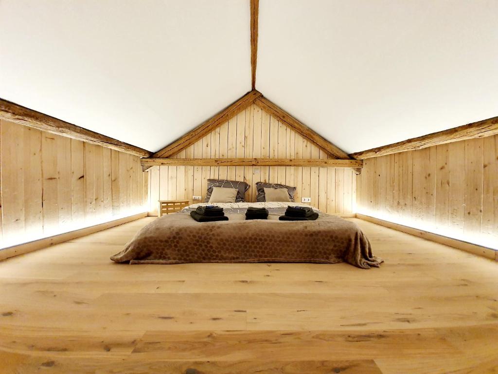 NiederweisSam's Cottage Suite的一间带一张大床的卧室,位于带木墙的房间
