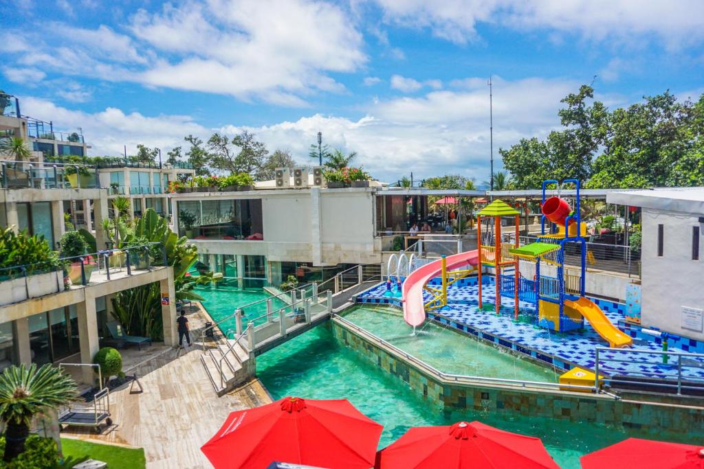 勒吉安巴厘岛水明漾富丽华海滩酒店的一个带水上滑梯的水上公园的游泳池