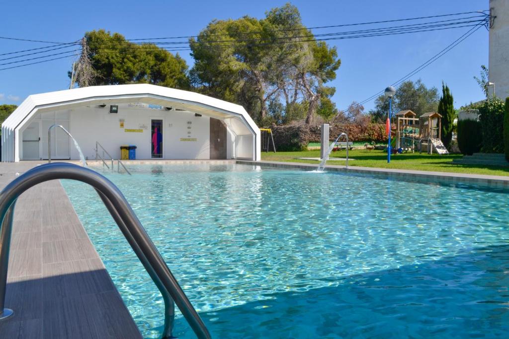 贝尼多姆布兰卡露营竞技场酒店的白色建筑旁边的游泳池