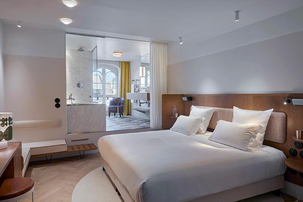 巴黎Hôtel du Sentier的一间带大床的卧室和一间浴室