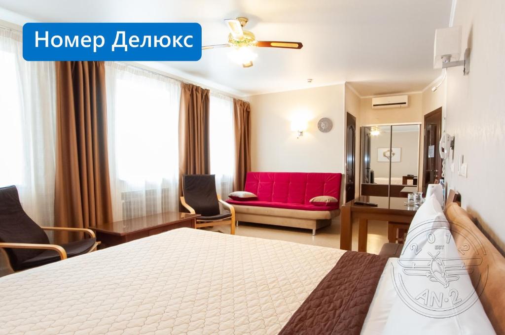 哈尔科夫Antwo-Hotel的酒店客房,配有一张床和一张红色的沙发