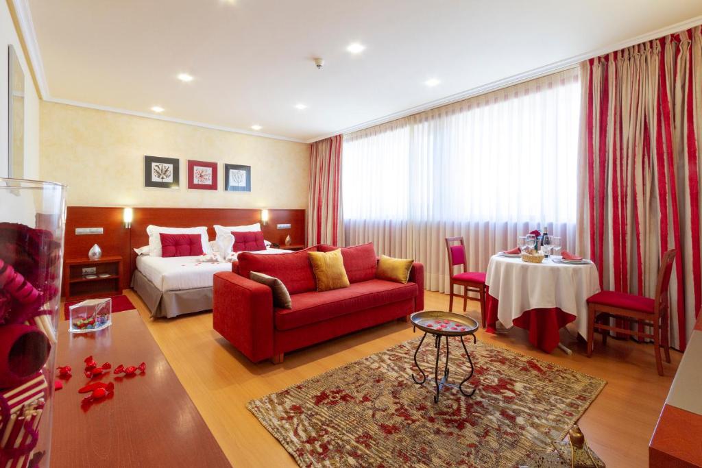 奥伦塞Hotel MIRAVALLE的酒店客房,配有一张床和一张红色的沙发