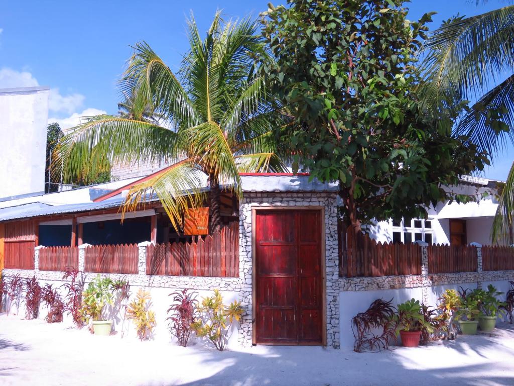 呼拉乎拉日出酒店的一座红色门和棕榈树的房子