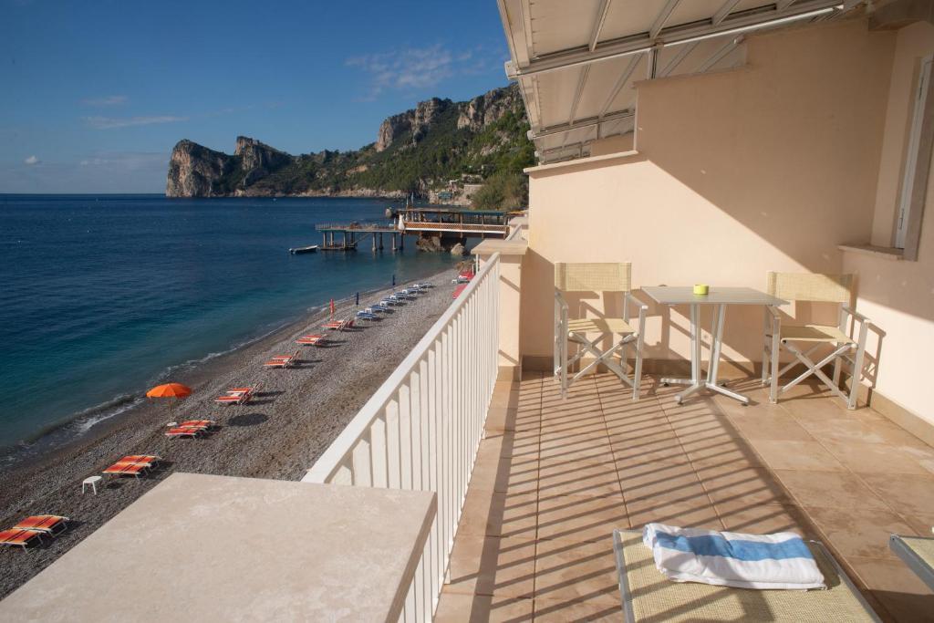 马萨鲁布朗斯Taverna Del Capitano的一个带桌椅和海滩的阳台