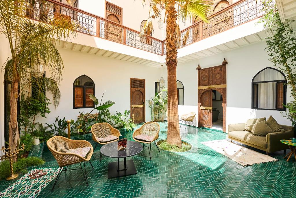 马拉喀什Riad Dar Yasaman的客厅配有棕榈树和椅子