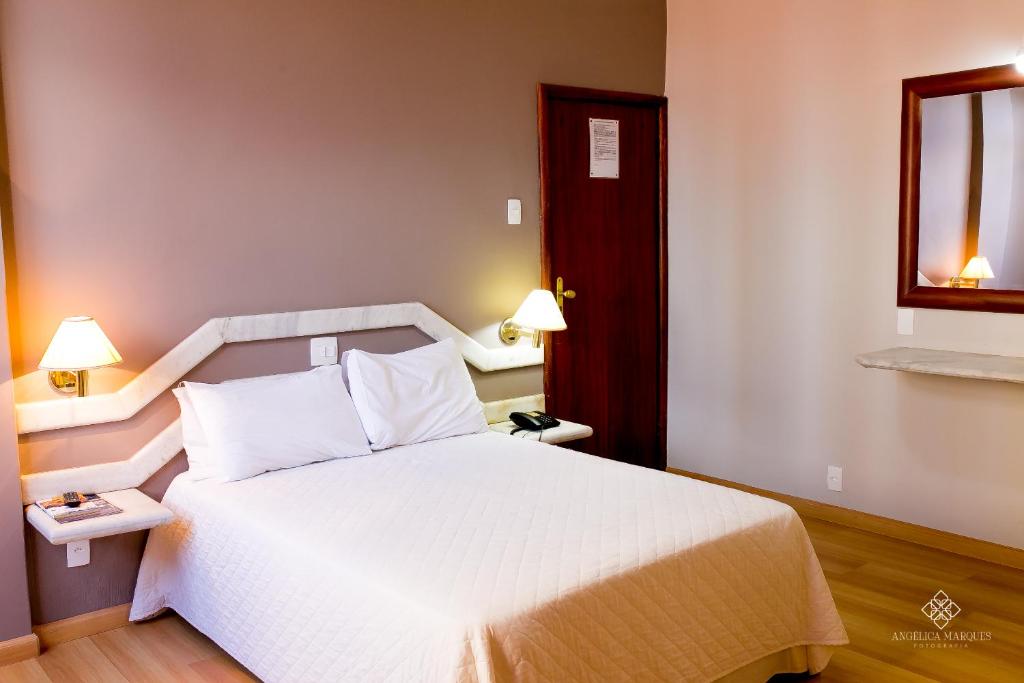 瓦尔任阿Fenicia Palace Hotel的卧室配有白色的床和窗户。