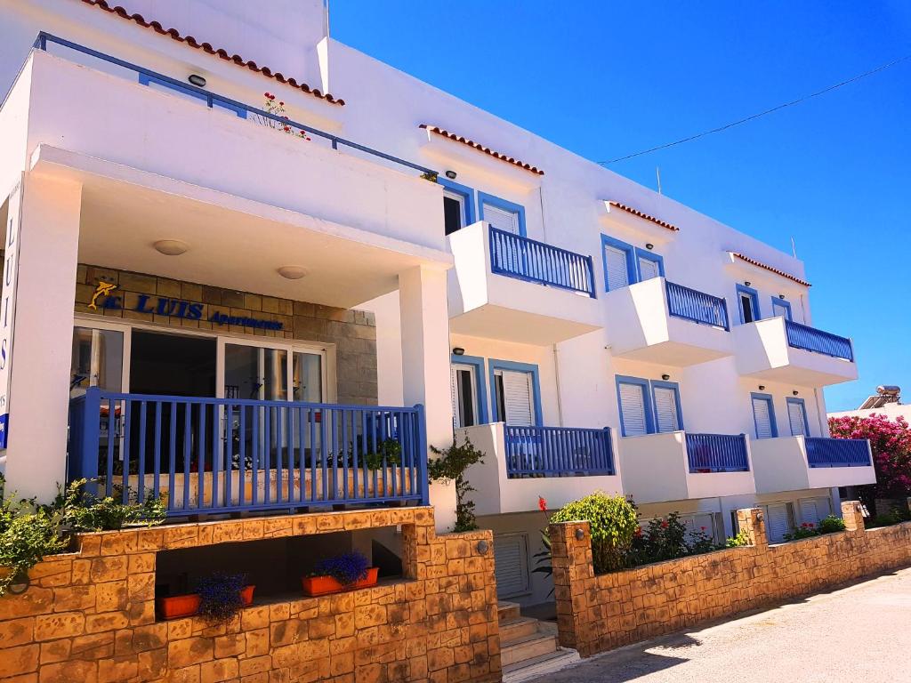 马斯蒂查里Luis Apartments的一座大型白色建筑,设有蓝色的阳台