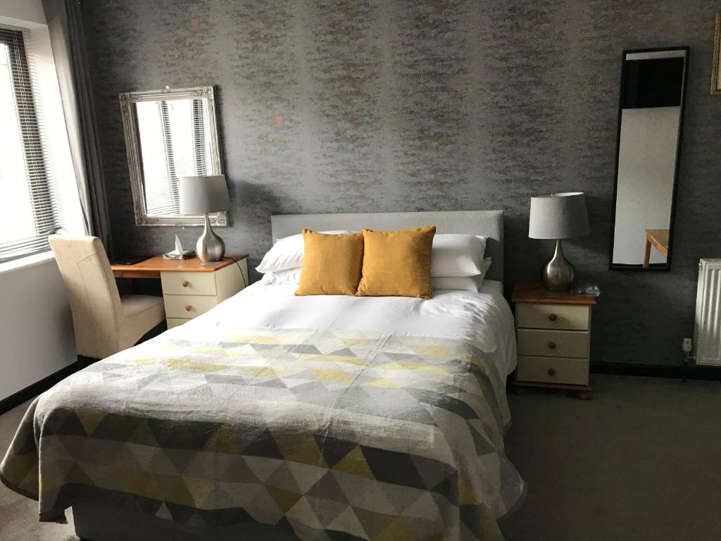 奥克姆六号客房公寓的一间卧室配有一张床、两张桌子和两盏灯。