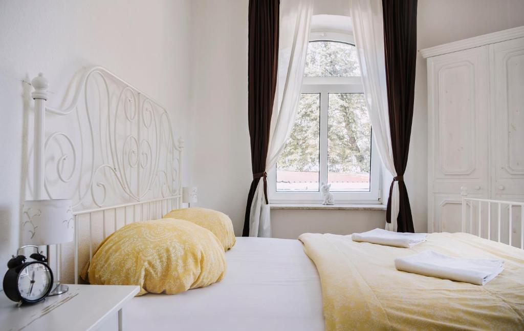 耶拿金伯莎膳食公寓的一间白色卧室,配有两张床和窗户