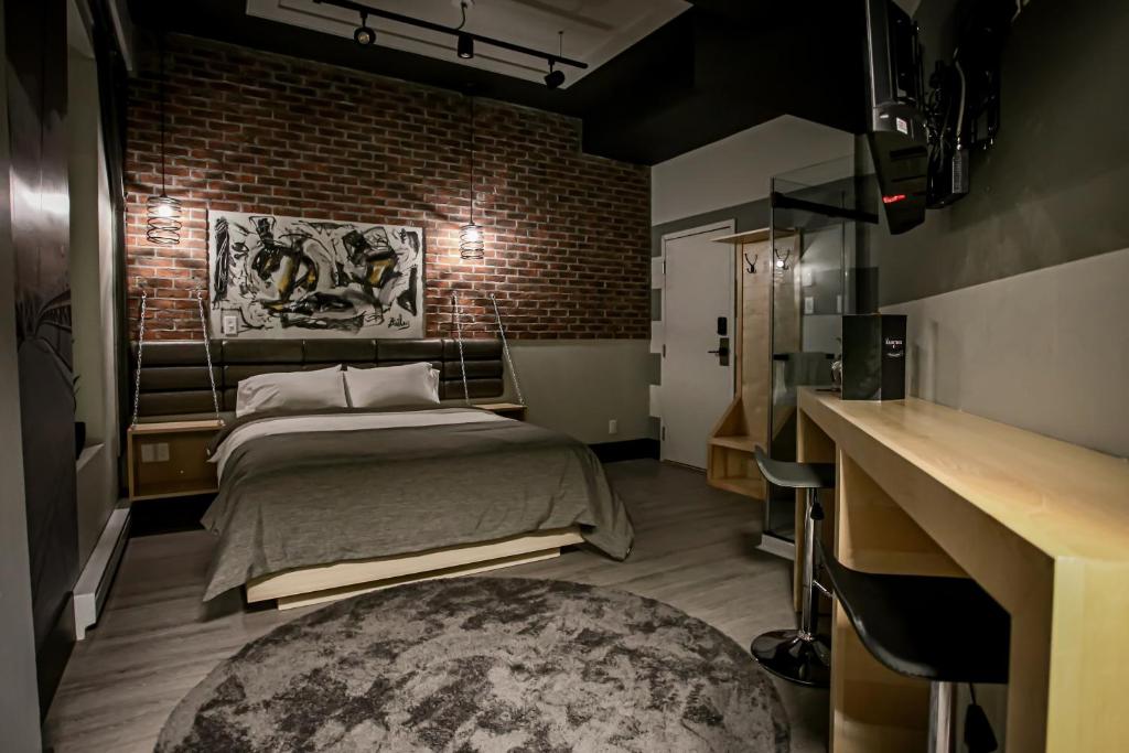 肖维尼根La Suite Hébergements的一间卧室设有一张床和砖墙