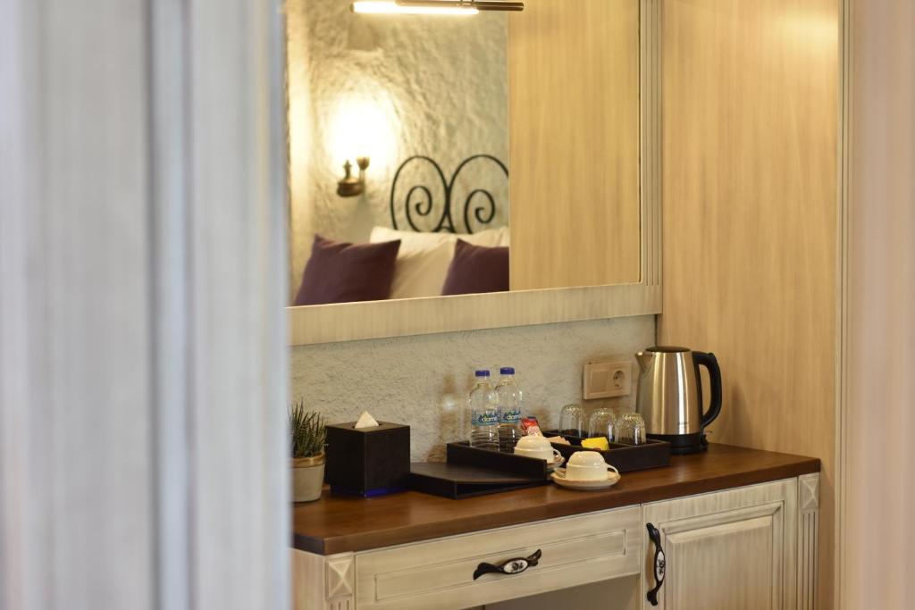 伊兹密尔Alaçatı Aura Plus的厨房配有带咖啡壶和镜子的柜台