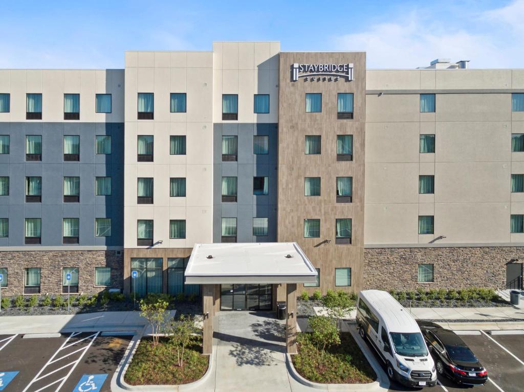 德卢斯Staybridge Suites - Atlanta NE - Duluth, an IHG Hotel的停泊在停车场的一辆面包车的酒店大楼