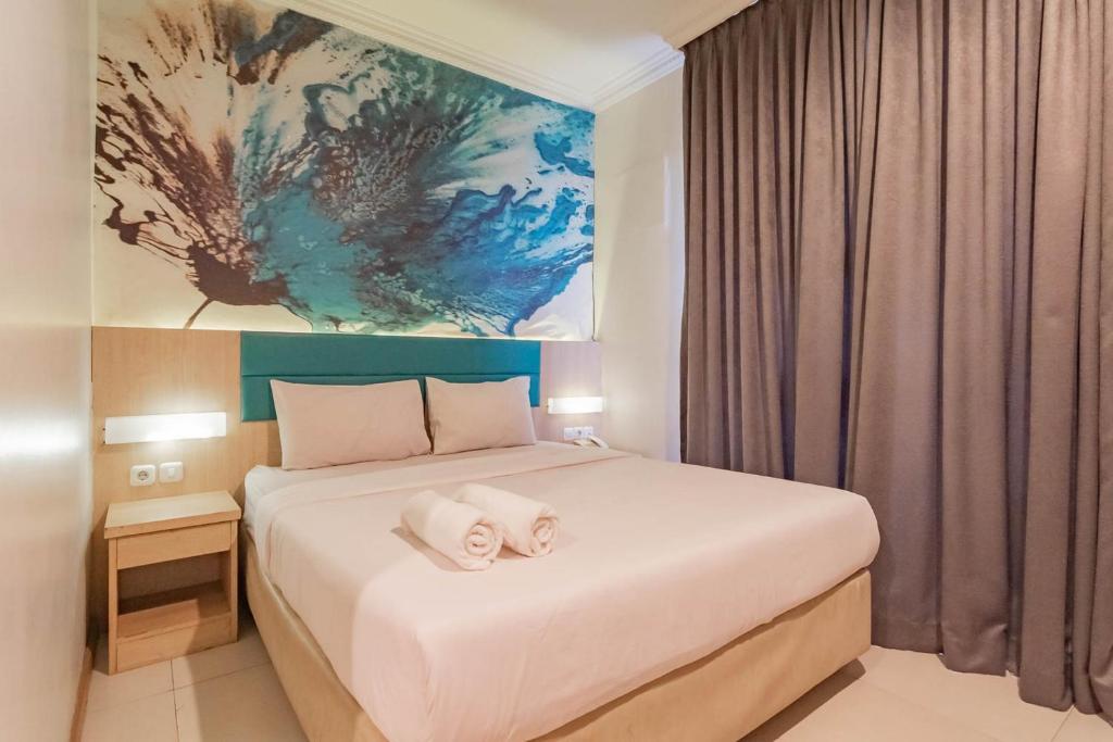 万隆RedDoorz At Hotel Arimbi Dewi Sartika Baru的一间卧室配有一张床,上面有两条毛巾
