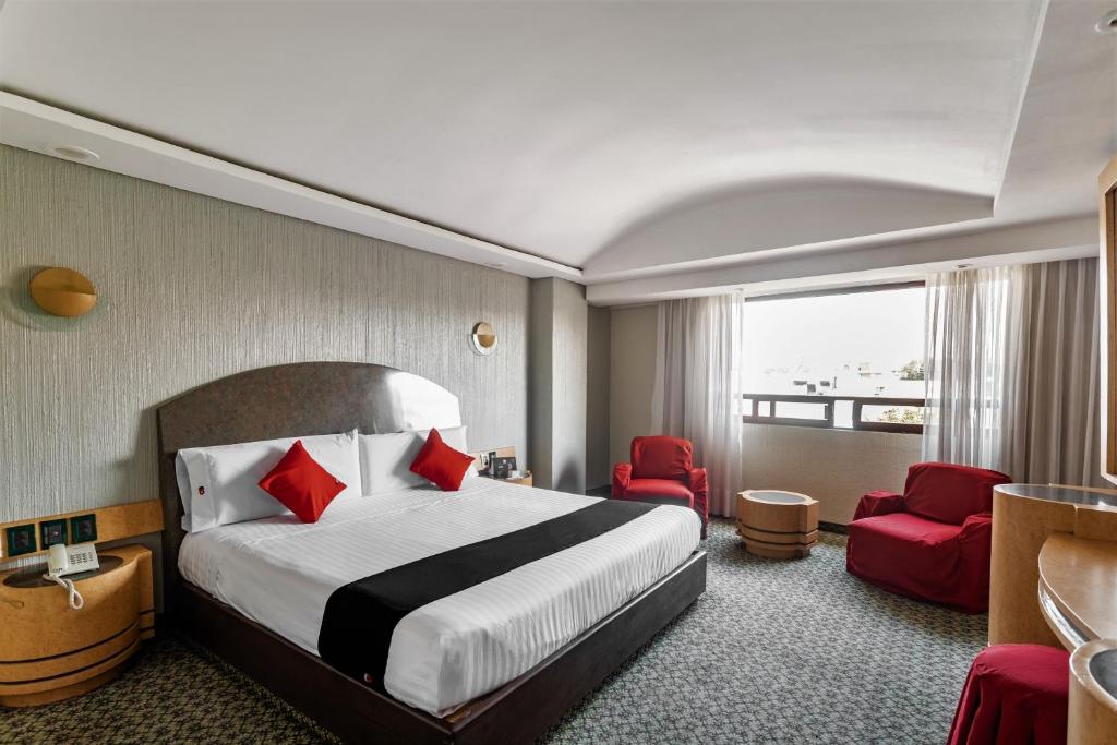 墨西哥城Capital O Andrade, Mexico City的酒店客房,配有一张床和两张红色椅子