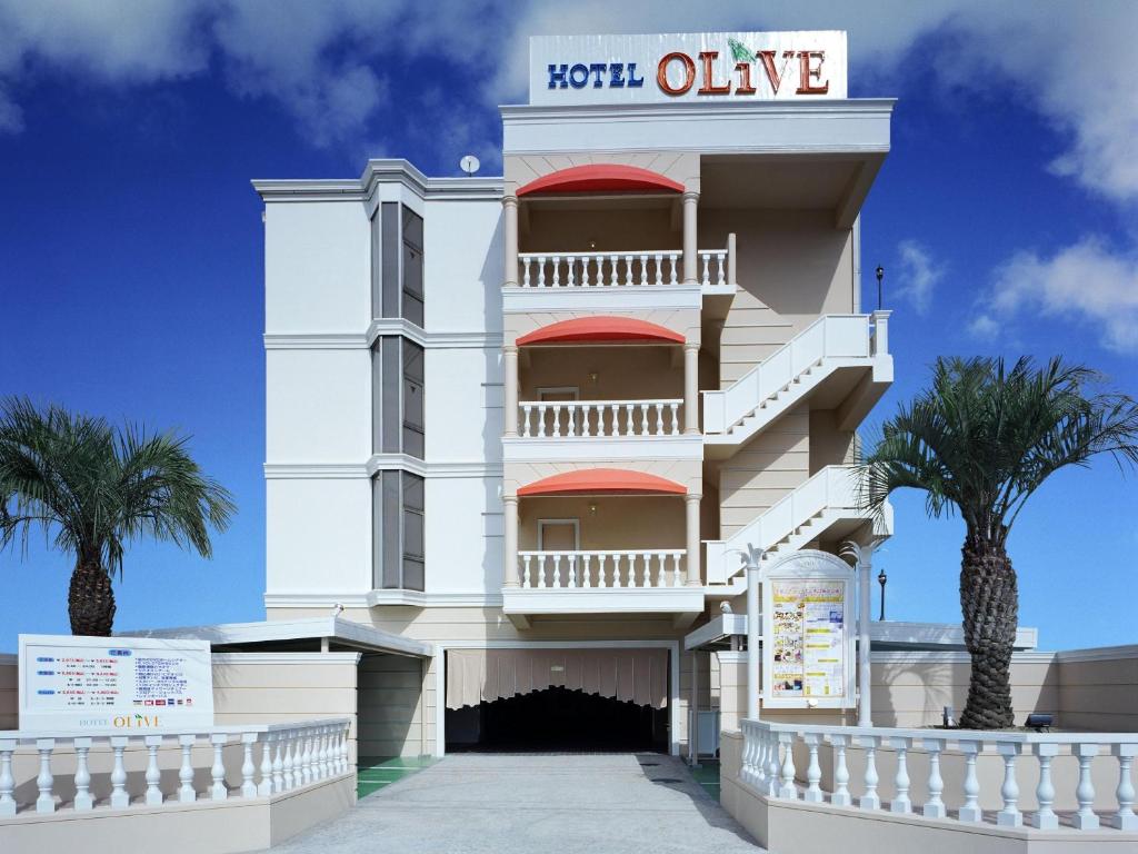 堺市Hotel Fine Olive Sakai的一座白色的建筑,前面有棕榈树