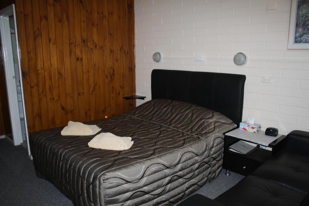 Nhill尼尔绿洲汽车旅馆的一间卧室配有一张床,上面有两条毛巾