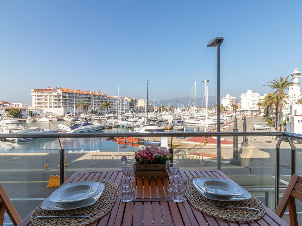 艾姆布里亚布拉瓦Apartment Del Port-5 by Interhome的阳台的桌子上摆放着盘子和餐巾,阳台上设有码头