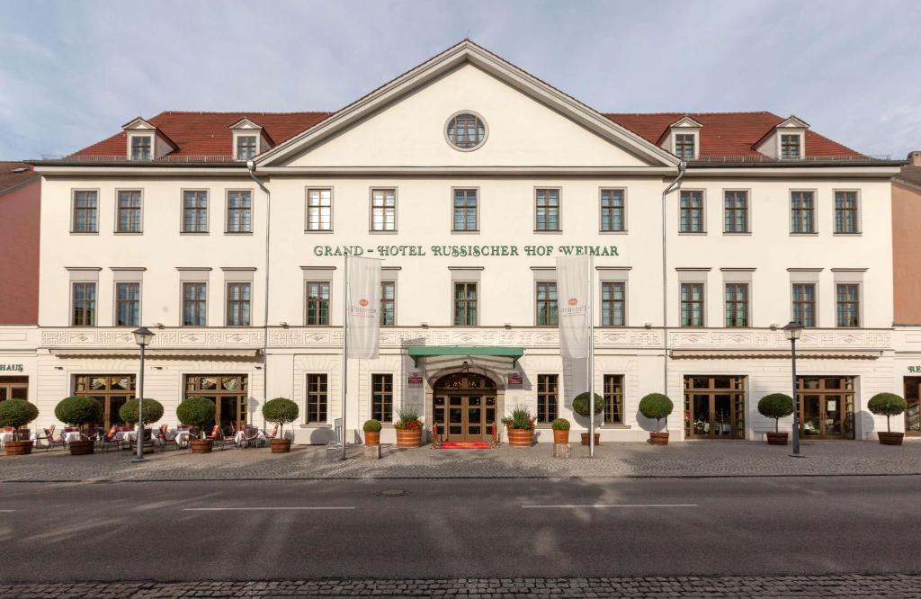 魏玛鲁瑟斯赫尔贝斯特韦斯特豪华酒店的一座白色的大建筑,上面有标志