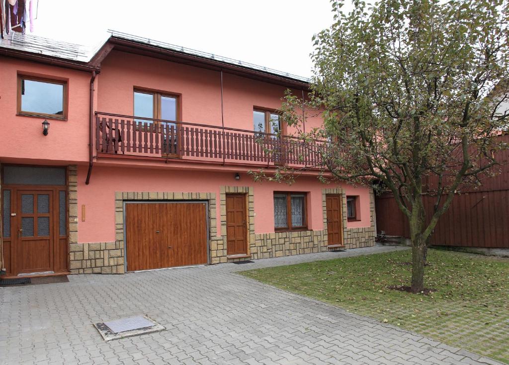 哈沃福卡Penzión Antónia的粉红色的房子,上面设有阳台
