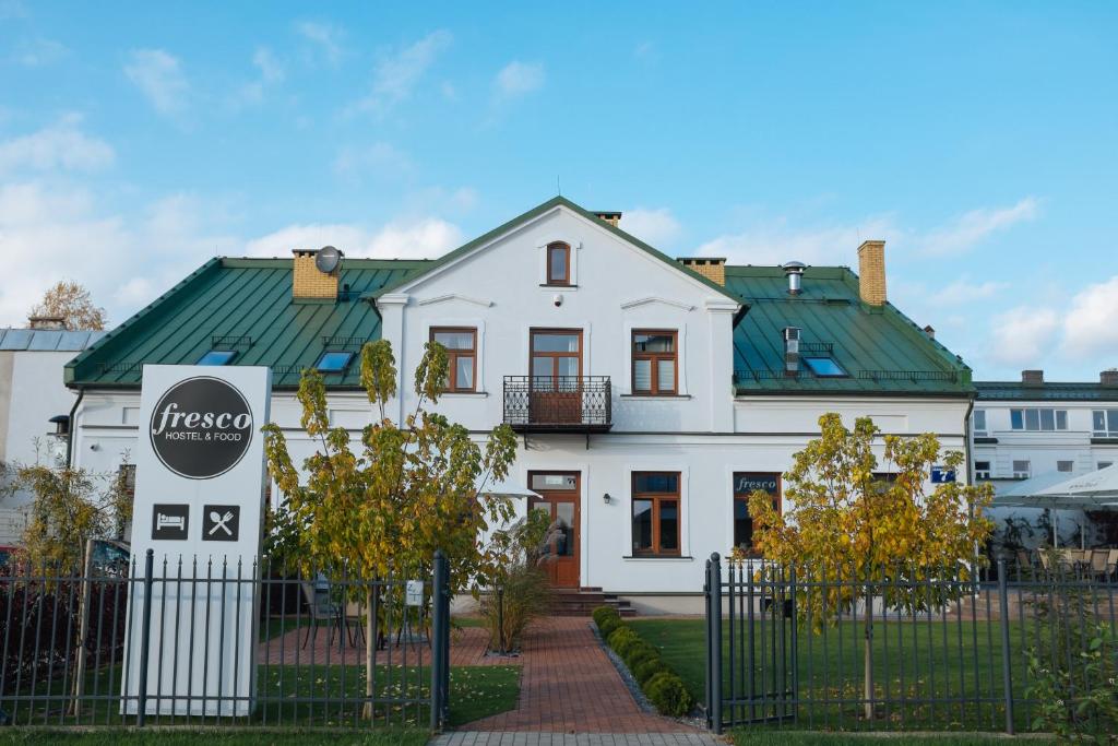 苏瓦乌基Fresco Hostel的白色的房屋,设有绿色的屋顶