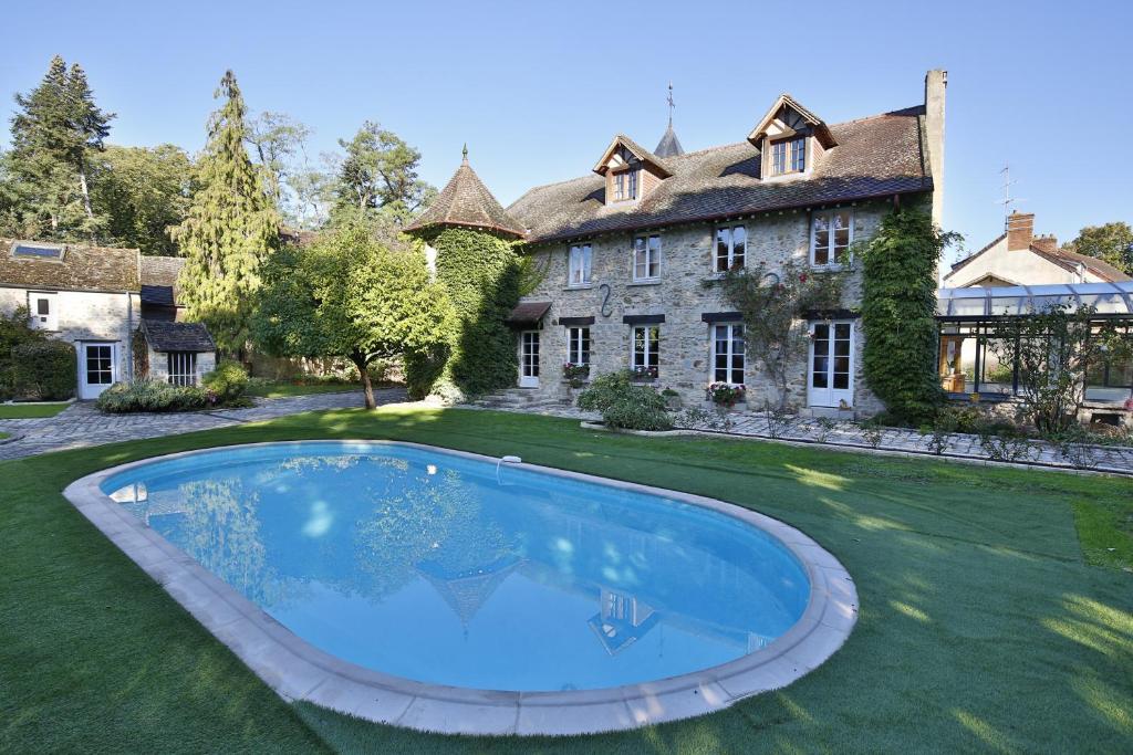 Nainville-les-RochesLe Clos Saint Lubin的房屋前方设有大型游泳池的庄园