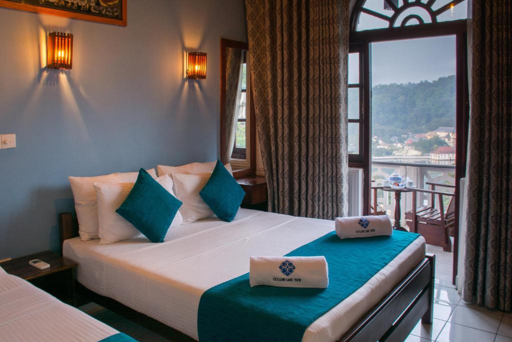 康提Ceyloni Lake Residency的一间卧室设有一张床和一个美景窗户。