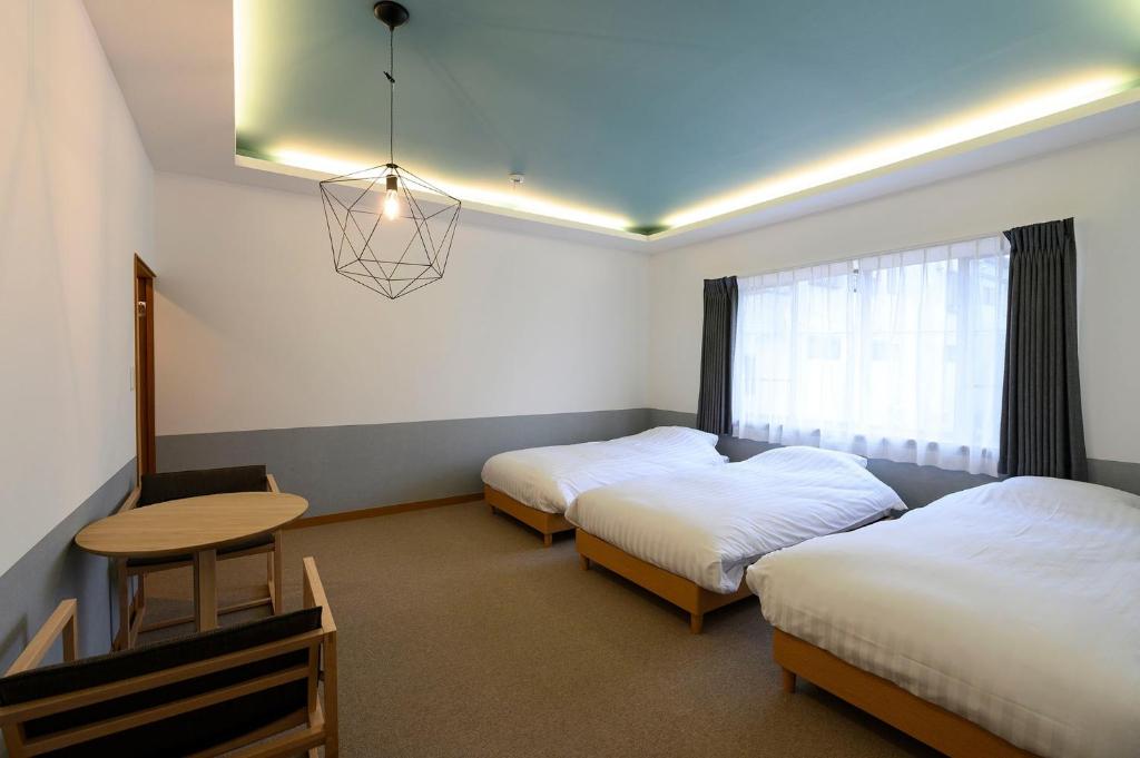 高山BEYOND HOTEL Takayama 4th - Vacation STAY 99852的客房设有两张床、一张桌子和一扇窗户。