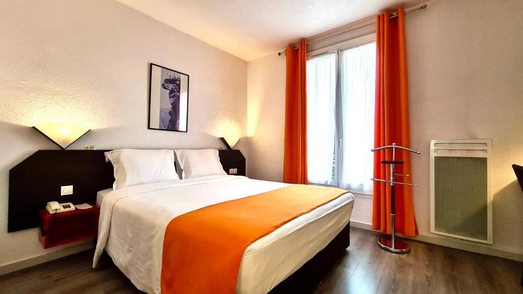 布洛涅-比扬古布洛涅家庭酒店的一间卧室设有一张大床和一个大窗户