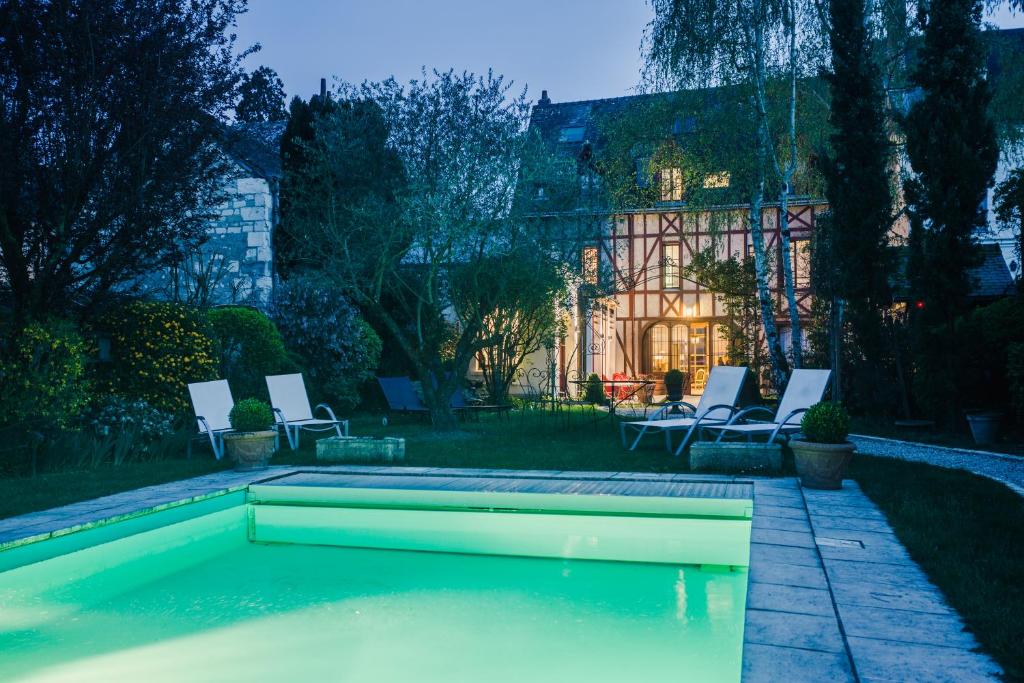 阿姆博斯魅力拉贝莱斯恩Spa酒店的一个带椅子的庭院和房子的游泳池