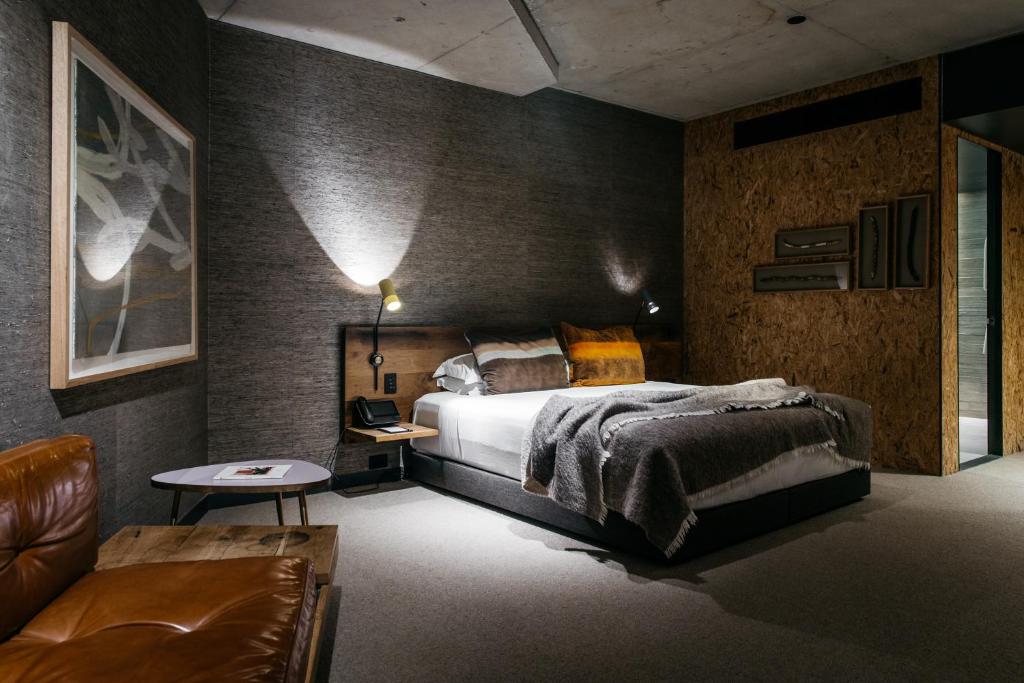 堪培拉欧沃洛尼施酒店的一间卧室配有一张床、一张桌子和一张沙发