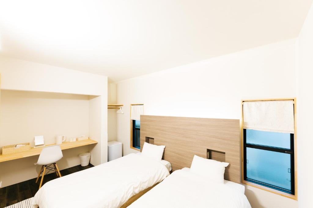 金泽B&B MIKAWA Info Centre - Kanazawa Fish Harbour的酒店客房设有两张床和窗户。