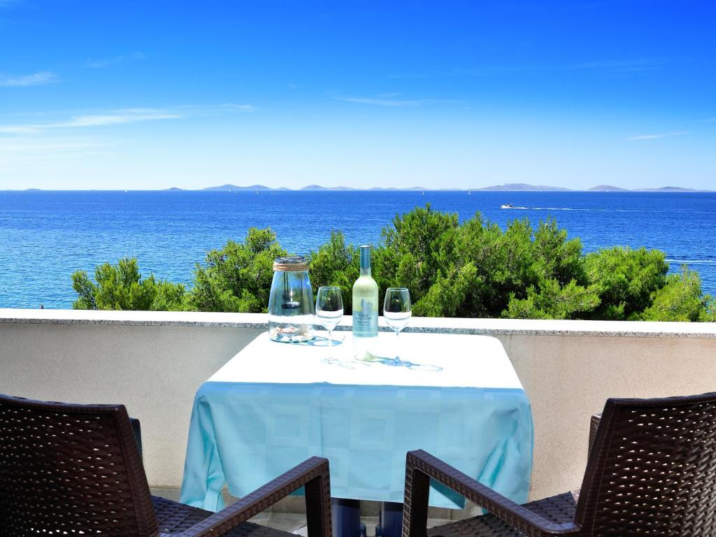 穆泰尔岛Villa Ana的阳台上配有带葡萄酒瓶和玻璃杯的桌子