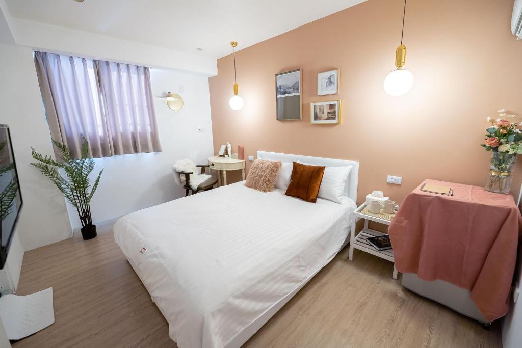 台南九月的卧室配有白色的床和桌子