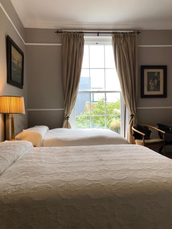 都柏林哈维斯酒店的一间卧室设有两张床和窗户。