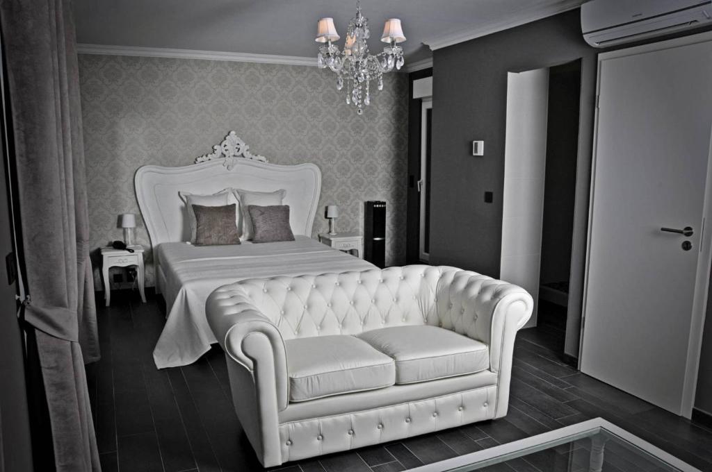 列日V E R O N E - Rooms & Suites - Liège - Rocourt的卧室配有白色的床和沙发