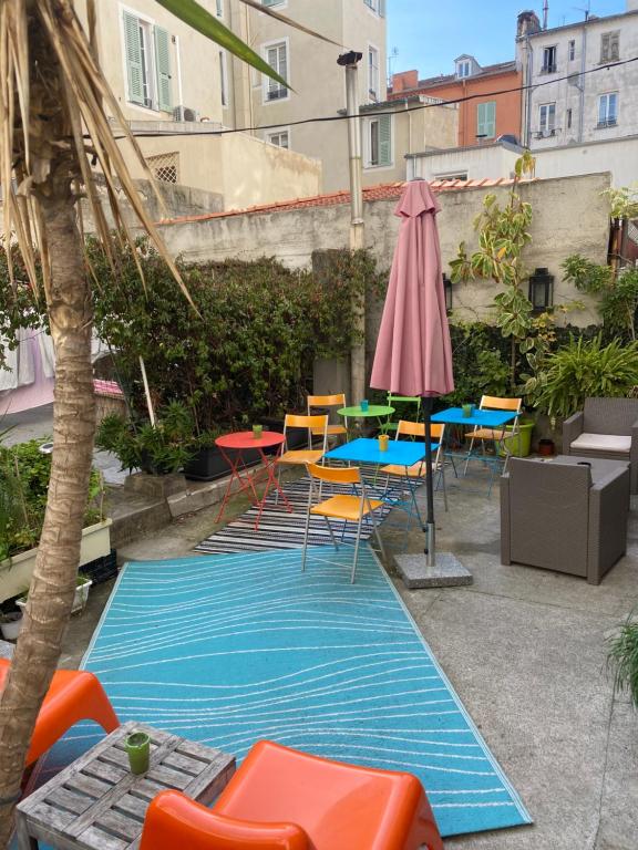 尼斯Le Pastoral的一个带椅子和桌子的游泳池以及一把遮阳伞