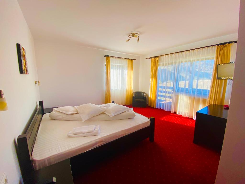 丰达塔盆苏尼索莱旅馆的一间卧室配有一张铺有红地毯的床