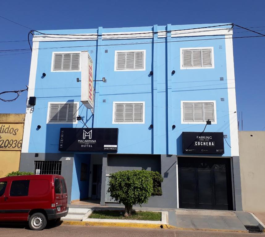 GualeguaychúMacaripana的前面有一辆红色货车的蓝色建筑