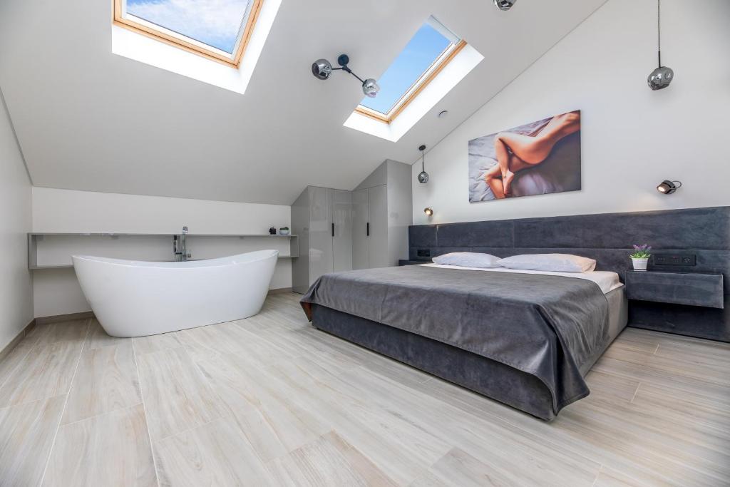 帕兰加M50 Apartments的一间卧室设有一张大床和一个浴缸