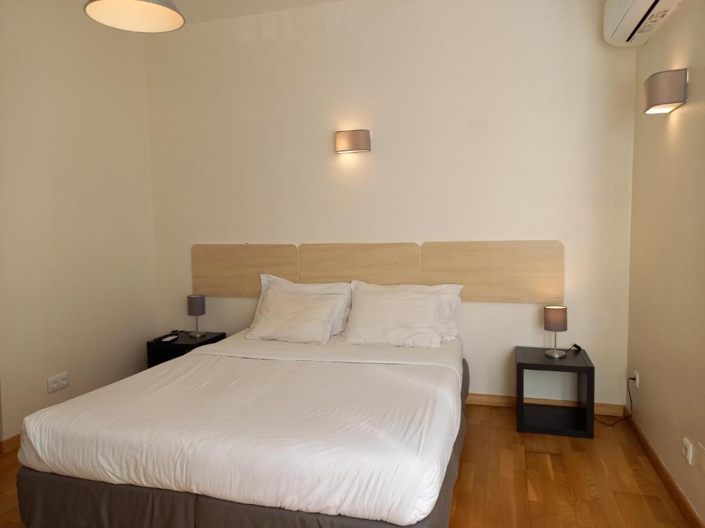 里斯本桑托斯住宿加早餐旅馆的一间卧室配有一张带白色床单和两盏灯的床。