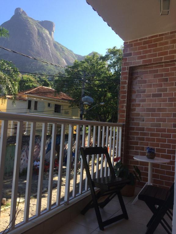 里约热内卢Casa Zona Sul的一个带桌子和山脉的阳台的椅子