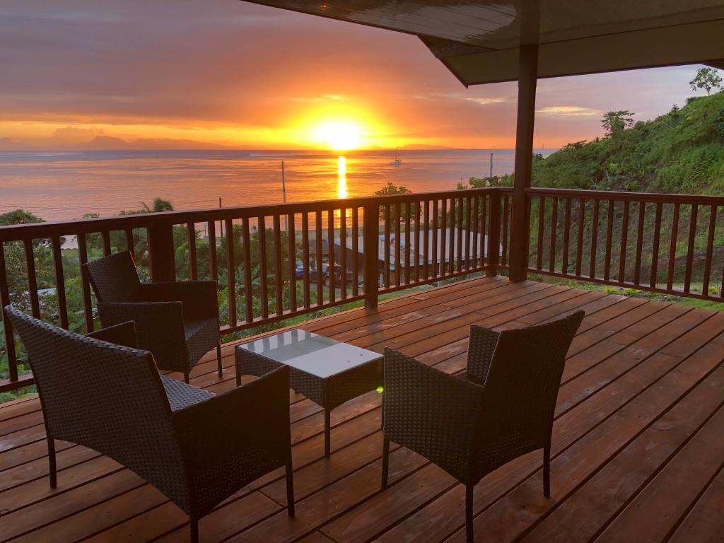 FitiiBienvenue au Mati House的一个带椅子和桌子的甲板,享有日落美景