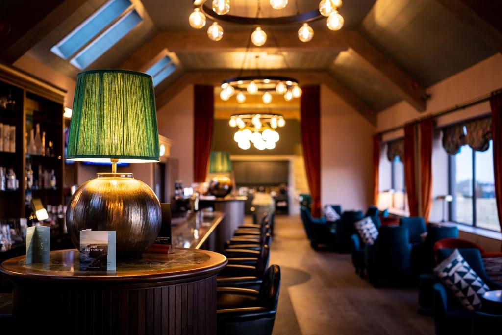 巴利卡斯尔The Salthouse Hotel的餐厅设有酒吧,配有椅子和灯