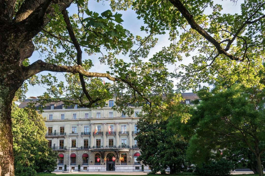 日内瓦日内瓦梅特罗博尔酒店的前面有树木的白色大建筑