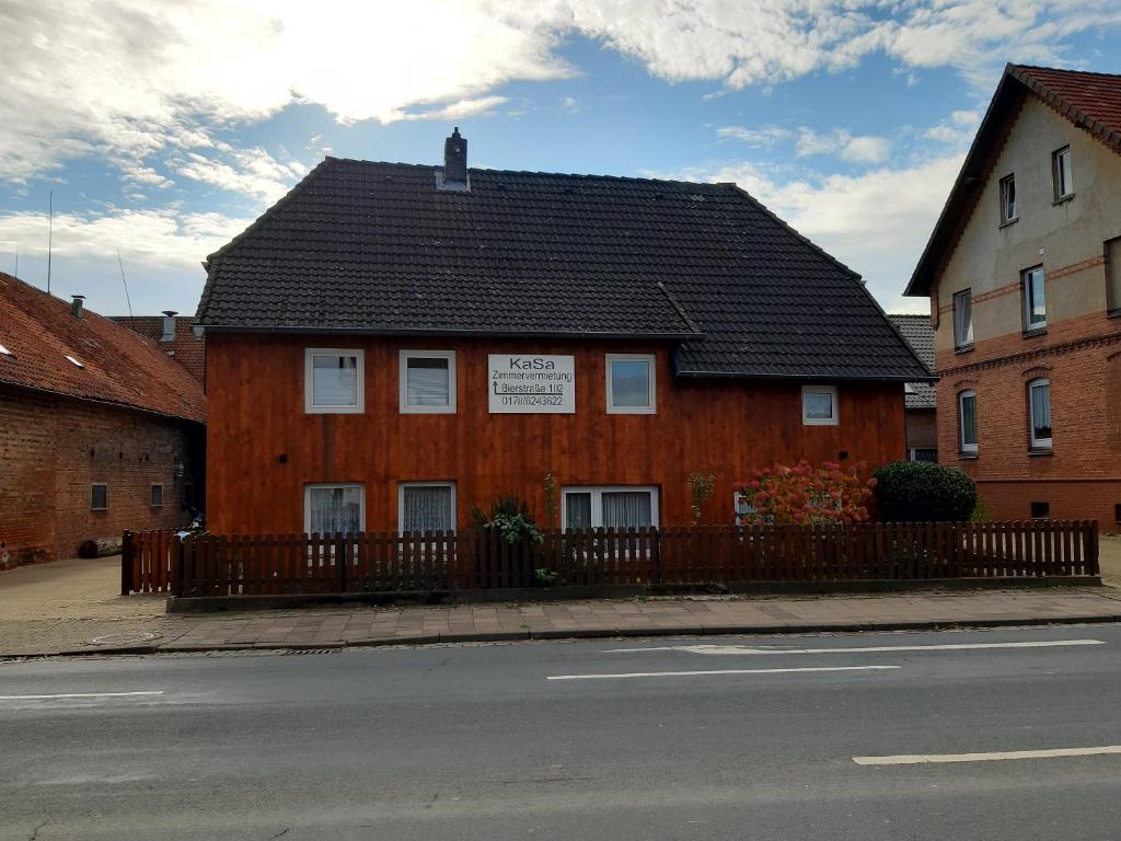 Groß LafferdeZimmervermietung KaSa的一条黑色的街道上,有黑色屋顶的棕色建筑