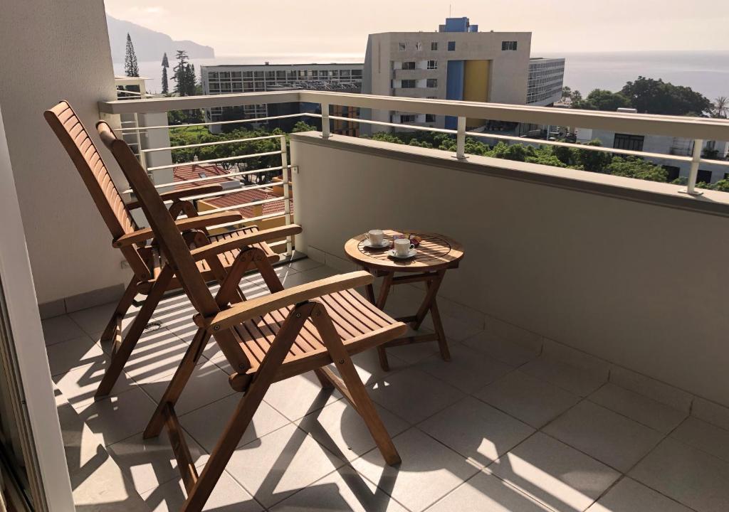 丰沙尔Dona I House - In Funchal with free parking的阳台配有2把椅子和1张桌子